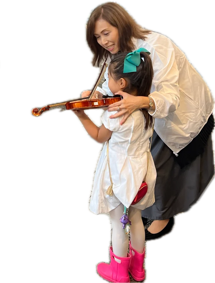 先生に支えられて、はじめてヴァイオリンを構える女の子