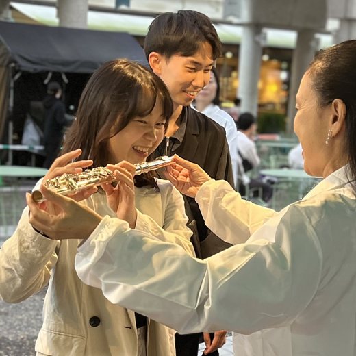 先生に教わりながら笑顔でフルートを構える女の子